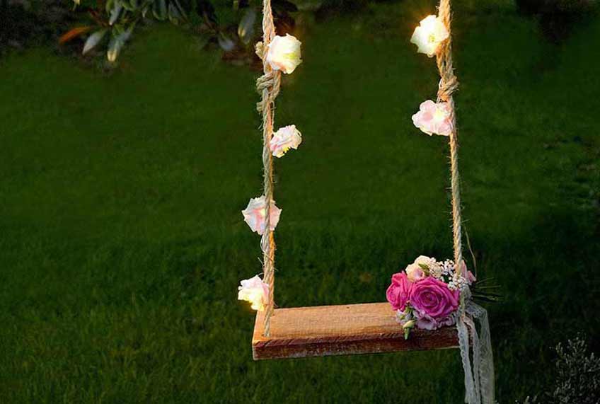 Wickle Lichterketten um die Hochzeitsschaukel für einen Hingucker bei Tag und Nacht