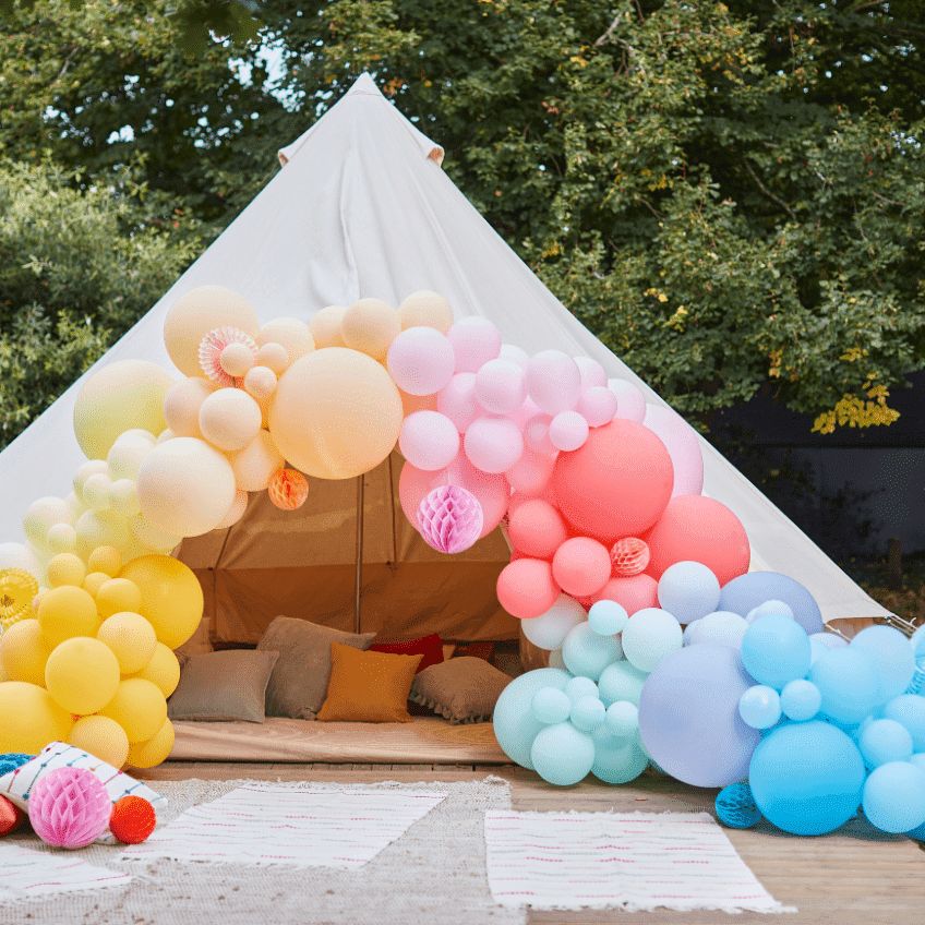 Ein gemütliches Gartenzelt mit prächtiger Ballongirlande als kleines Highlight auf der Gartenhochzeit