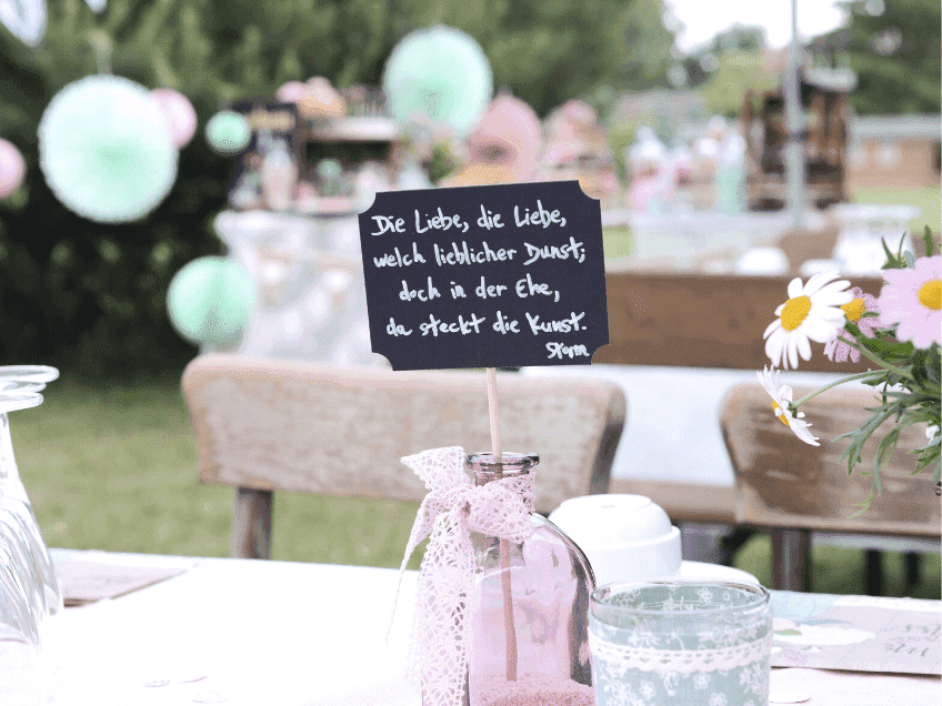 Tischdeko-Idee für die Gartenhochzeit - auf jeden Tisch ein Spruch über die Liebe (c) Nadine Barthold