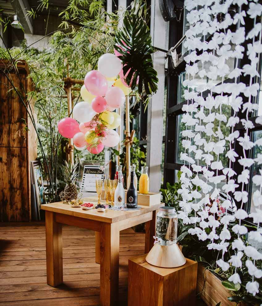 Dekoriere deine Mimosa Bar mit Ballongirlande und Blumenvorhang  