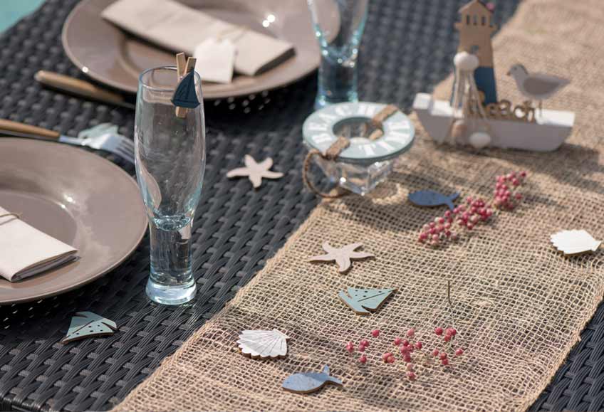 Jute-Tischläufer und kleine Meeres-Motive aus Holz als Hochzeits-Tischdeko