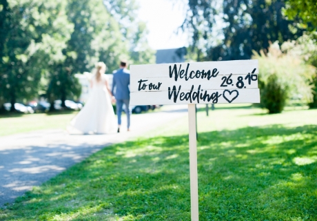Ein Willkommens-Schild begrüßt die Hochzeitsgäste und weist ihnen den Weg